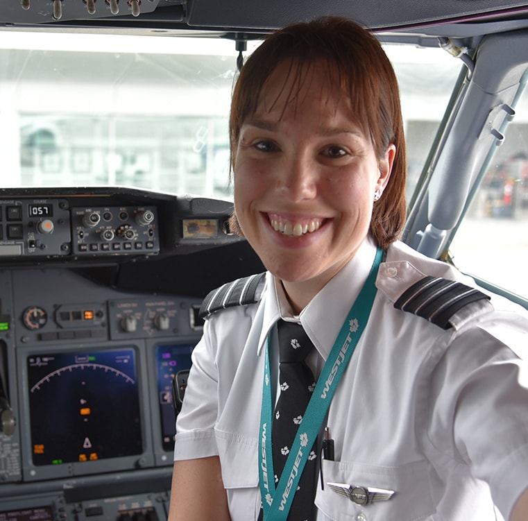 A smiling pilot inside a plane